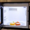 Modern apartment kitchen showcasing a clean microwave and healthy ingredients.